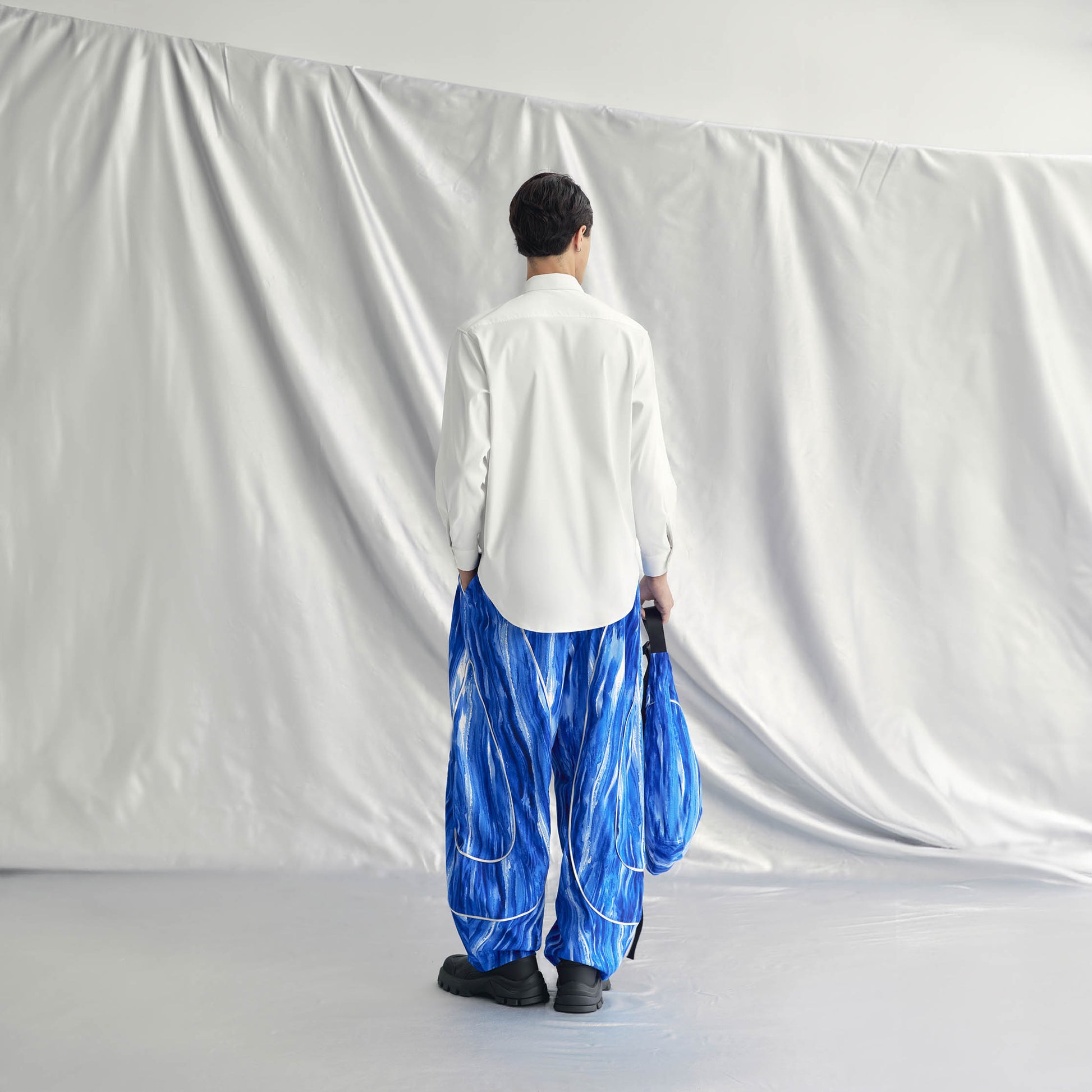 AEREN PANTS | BLUE with wide legs, elastic waistband, drawstring hem, side pockets, and a metallic line design.